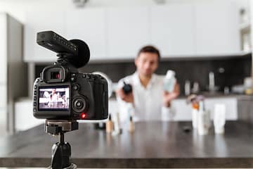 Handsome young man filming his video blog episode