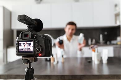 Handsome young man filming his video blog episode