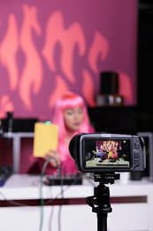 Influencer holding notebook showing product in front of camera while recording review